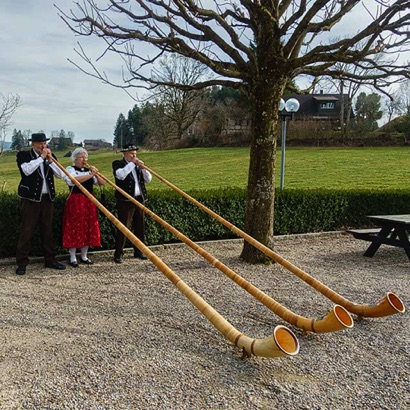 2023-03-17_Affoltern im Emmental bei der Schaukäserei begrüsst das Alphorntrio Silberhorn die Gäste eines Firmenanlasses.